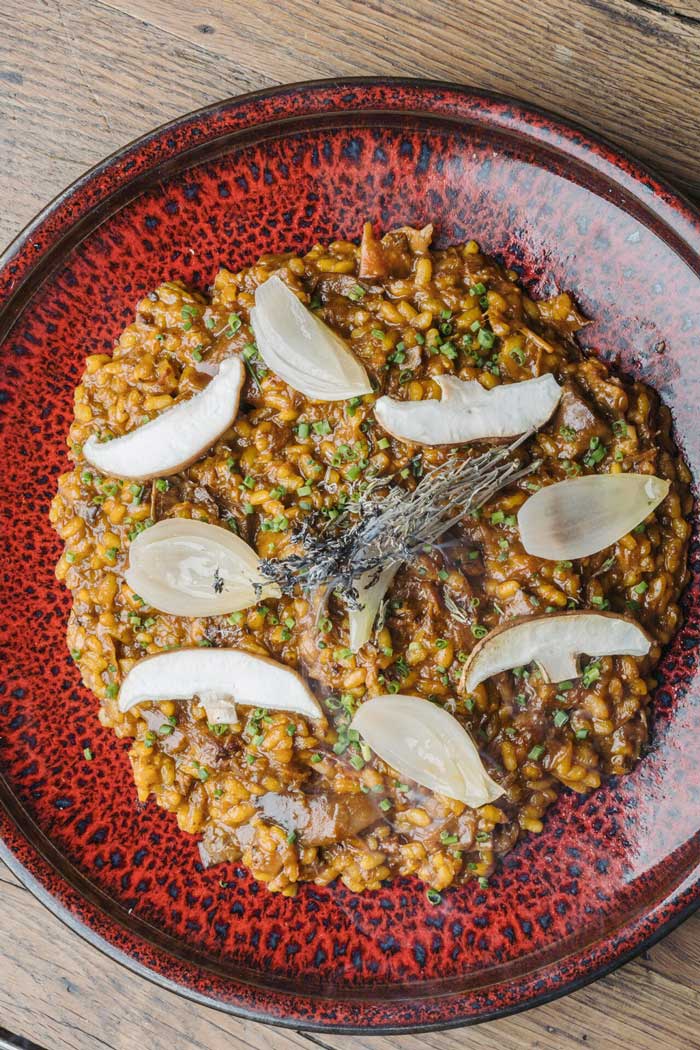 Arroz meloso con costillas de cerdo ibérico y setas de temporada, servido en restaurante Kulto en Madrid Retiro