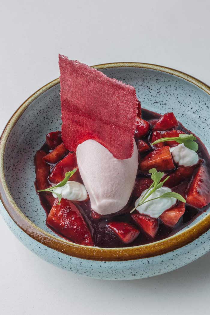 Postre de fresas con yogurt natural y cilantro fresco, servido en restaurante Kulto del barrio Retiro en Madrid